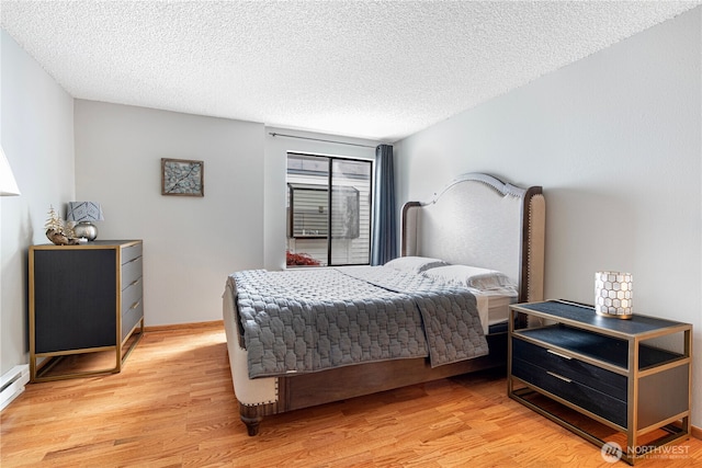 15930 NE 15th St, Bellevue, WA 98008 - bedroom featuring light wood-style floors, a textured ceiling, and a baseboard heating unit