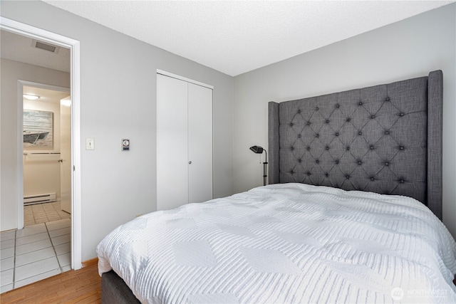 15930 NE 15th St, Bellevue, WA 98008 - bedroom with a baseboard heating unit, wood finished floors, and a closet