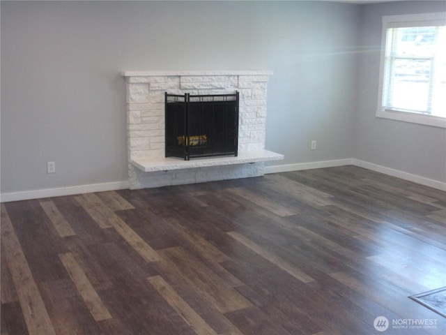 unfurnished living room with wood finished floors, a fireplace, and baseboards