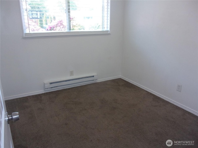 empty room featuring a baseboard radiator, healthy amount of natural light, and dark colored carpet