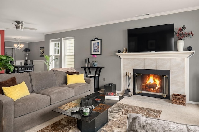 living room with crown molding, ceiling fan, and a fireplace