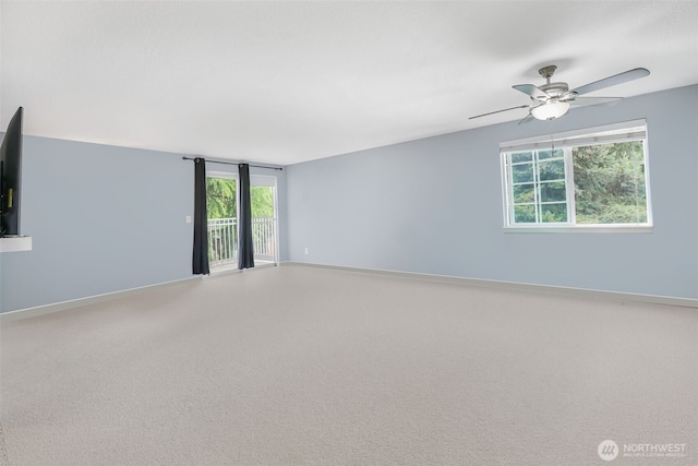 empty room featuring plenty of natural light, ceiling fan, and baseboards
