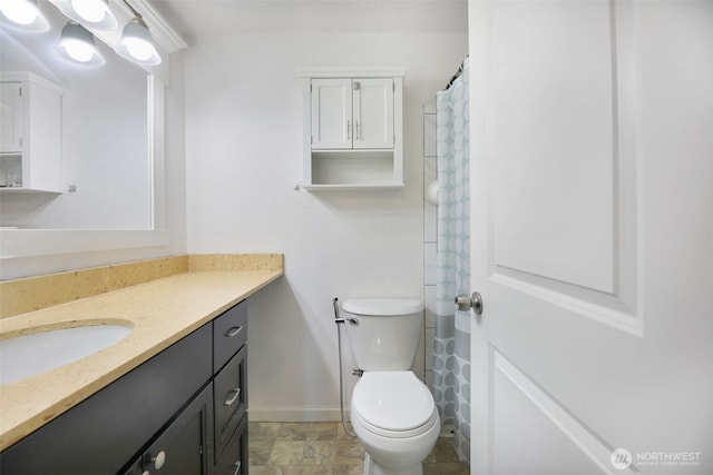 full bath featuring baseboards, vanity, and toilet