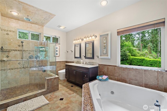 35449 34th Ave S, Auburn, WA 98001 - bathroom featuring healthy amount of natural light, a shower stall, a tub with jets, vanity, and wainscoting