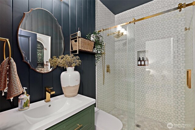 full bathroom featuring a stall shower, vanity, and toilet