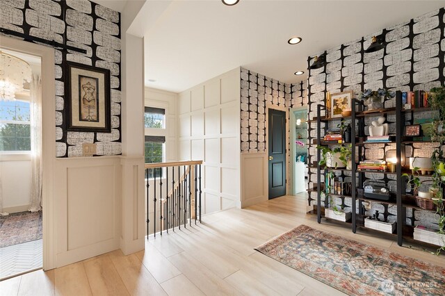wine cellar with a decorative wall, wood finished floors, recessed lighting, and a wainscoted wall