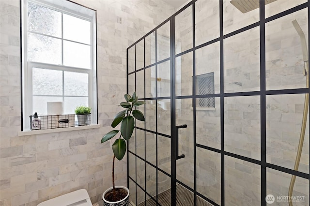 bathroom featuring tiled shower and healthy amount of natural light
