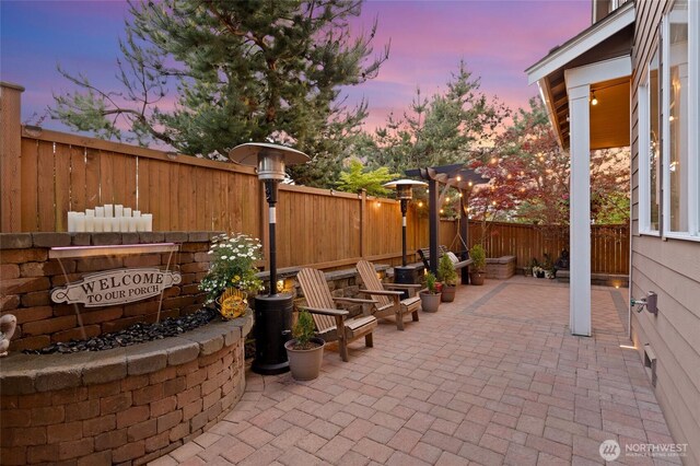 patio terrace at dusk with a fenced backyard