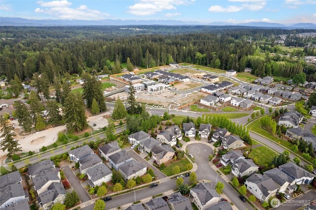 aerial overview of property's location featuring a forest and nearby suburban area