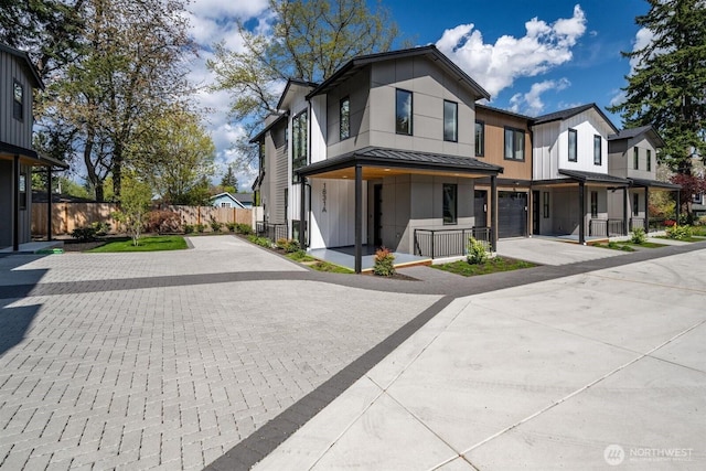 1831 4th St Unit A, Kirkland, WA 98033 - view of front facade featuring concrete driveway, a standing seam roof, a garage, fence, and metal roof