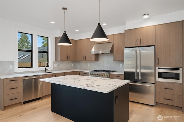 1831 4th St Unit A, Kirkland, WA 98033 - kitchen featuring appliances with stainless steel finishes, wall chimney range hood, a sink, light wood-type flooring, and recessed lighting