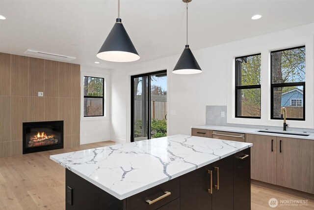 1831 4th St Unit A, Kirkland, WA 98033 - kitchen with a sink, light wood-style flooring, light stone countertops, and recessed lighting