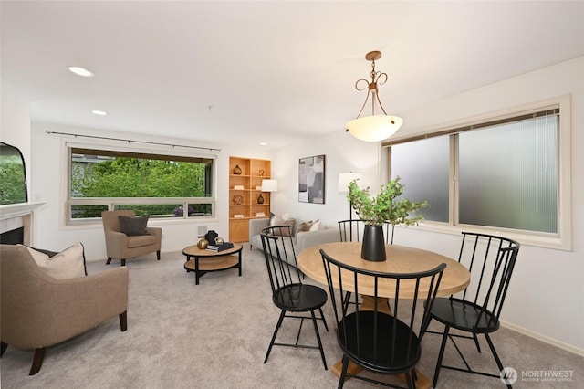 dining room with light colored carpet, a fireplace, recessed lighting, and baseboards