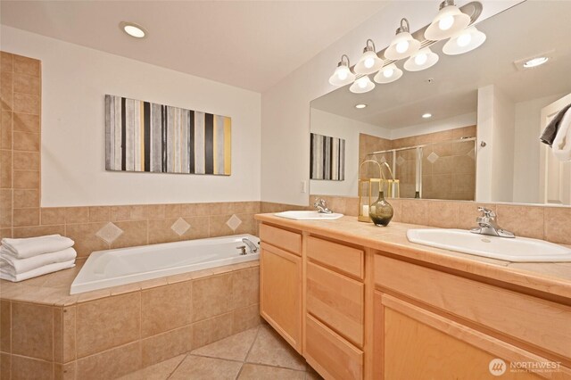 full bath with a shower stall, tile patterned floors, a garden tub, and double vanity