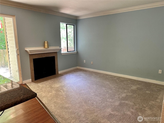 unfurnished living room featuring a fireplace, ornamental molding, carpet floors, and baseboards