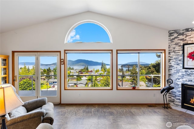 living area featuring a mountain view, lofted ceiling, and a fireplace