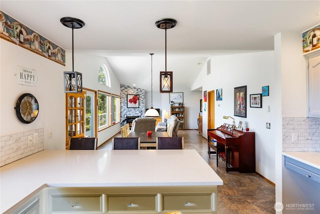 kitchen with tasteful backsplash, lofted ceiling, light countertops, a peninsula, and open floor plan
