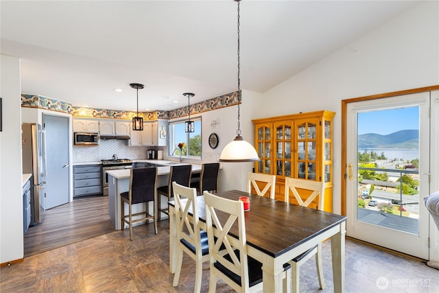 dining space featuring vaulted ceiling, a mountain view, and recessed lighting
