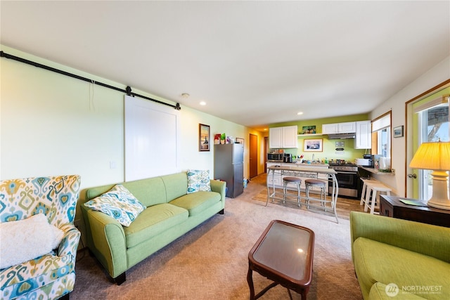 living room featuring recessed lighting, light colored carpet, and a barn door