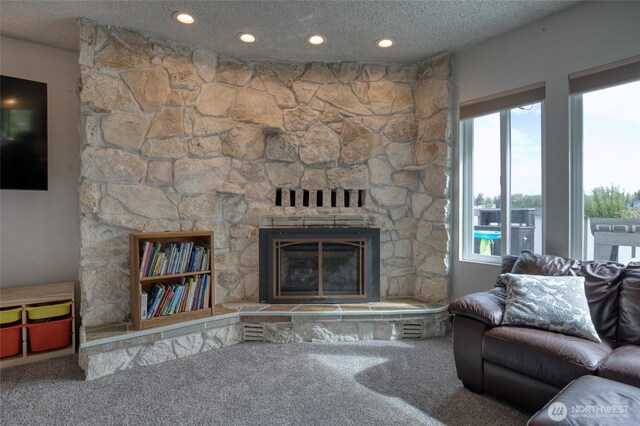 712 Mt Olympus Ave SE, Ocean Shores, WA 98569 - carpeted living area featuring a stone fireplace, recessed lighting, and a textured ceiling