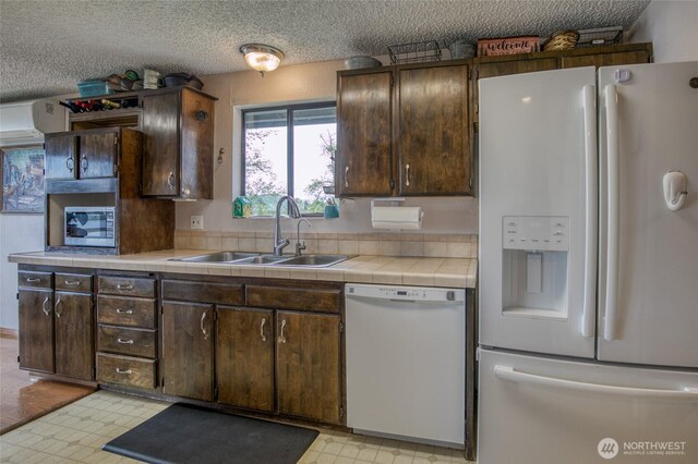712 Mt Olympus Ave SE, Ocean Shores, WA 98569 - kitchen with white appliances, a sink, dark brown cabinetry, a textured ceiling, and light floors