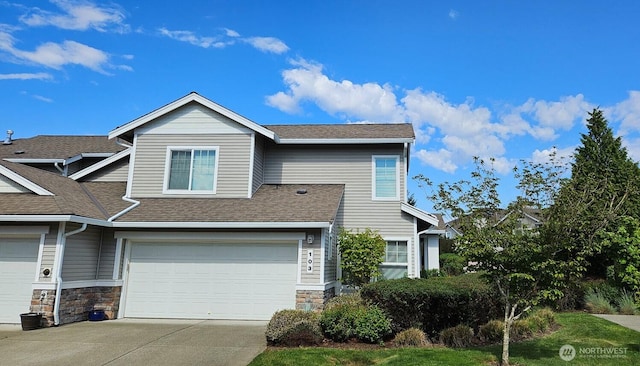 view of front of house with concrete driveway, a garage, roof with shingles, and stone siding