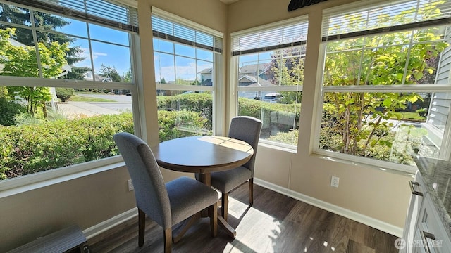 sunroom with baseboards, healthy amount of natural light, and wood finished floors