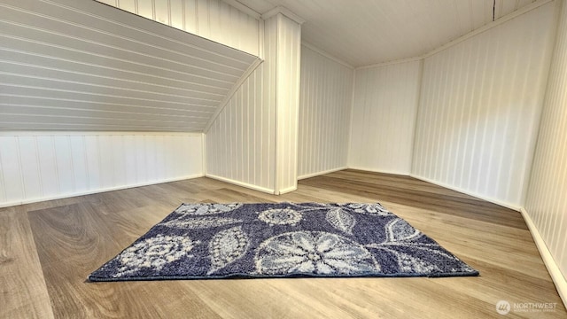 additional living space with wood finished floors and baseboards