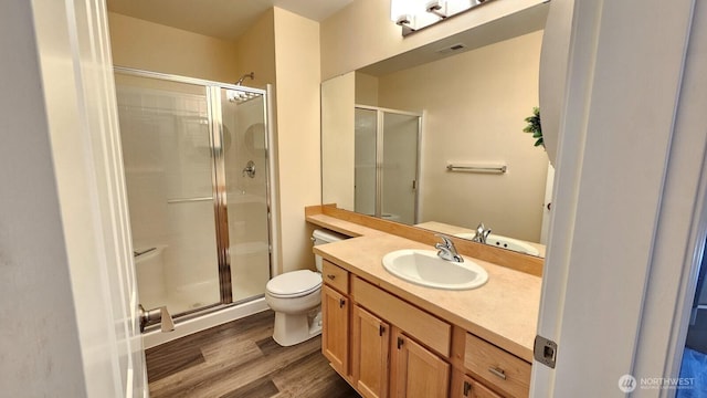 full bathroom with wood finished floors, a stall shower, toilet, and vanity