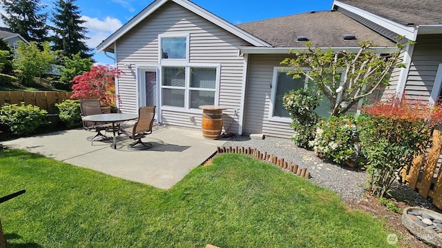rear view of property featuring a patio and roof with shingles