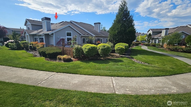 view of property exterior with a lawn, a chimney, and a residential view