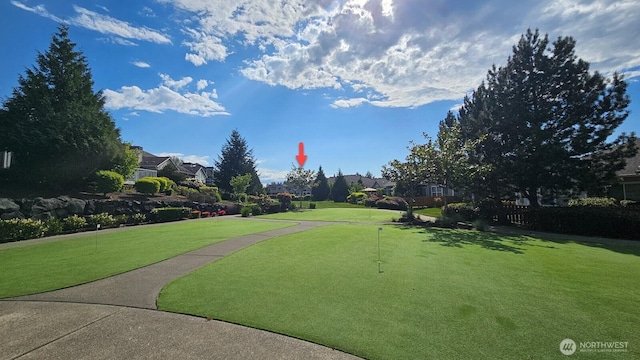 view of property's community with a putting area, a residential view, and a yard