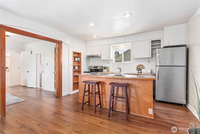 2721 Iron St, Bellingham, WA 98225 - kitchen with freestanding refrigerator, range with electric cooktop, white cabinetry, under cabinet range hood, and a sink