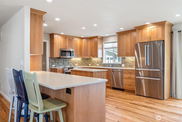 78 Whitten St, Richland, WA 99354 - kitchen with stainless steel appliances, light wood-style flooring, light countertops, decorative backsplash, and a peninsula