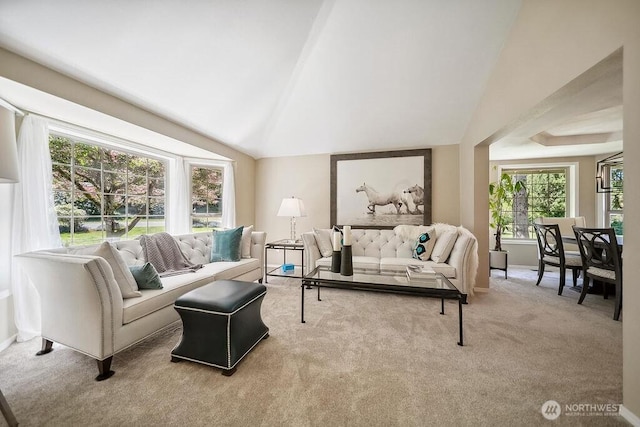 carpeted living room featuring lofted ceiling and baseboards