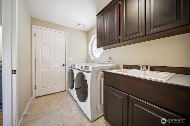 clothes washing area featuring cabinet space, washing machine and dryer, and baseboards