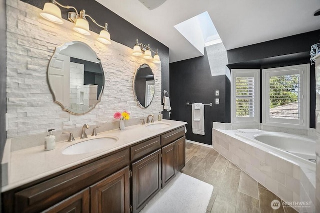 full bathroom featuring a skylight, a garden tub, and double vanity