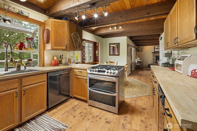 1632 Cattle Point Rd, Friday Harbor, WA 98250 - kitchen featuring dishwasher, double oven range, rail lighting, light wood-style floors, and a wooden ceiling with exposed beams