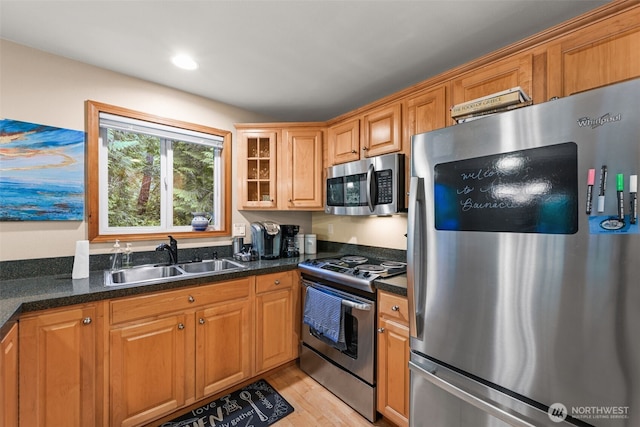 436 E Pointes Dr E, Shelton, WA 98584 - kitchen with appliances with stainless steel finishes, a sink, glass insert cabinets, light wood-type flooring, and brown cabinetry