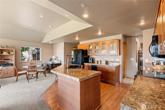 2541 Fancher Heights Blvd, East Wenatchee, WA 98802 - kitchen with a sink, black appliances, brown cabinetry, a center island with sink, and light wood finished floors