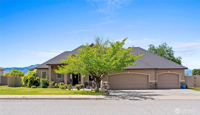 2541 Fancher Heights Blvd, East Wenatchee, WA 98802 - view of front of property with an attached garage, stucco siding, concrete driveway, a mountain view, and stone siding