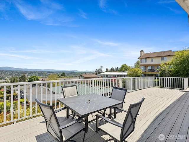 wooden terrace with a mountain view and outdoor dining area