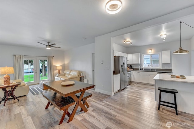 612 Hunt Ave, Sumner, WA 98390 - dining space with french doors, a ceiling fan, light wood finished floors, and baseboards