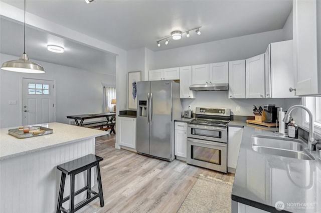 612 Hunt Ave, Sumner, WA 98390 - kitchen with appliances with stainless steel finishes, under cabinet range hood, a sink, light wood finished floors, and white cabinetry