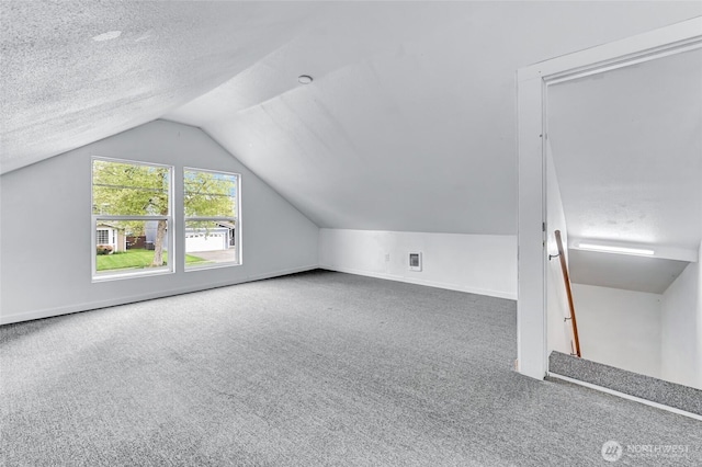 612 Hunt Ave, Sumner, WA 98390 - additional living space featuring carpet floors, vaulted ceiling, and a textured ceiling