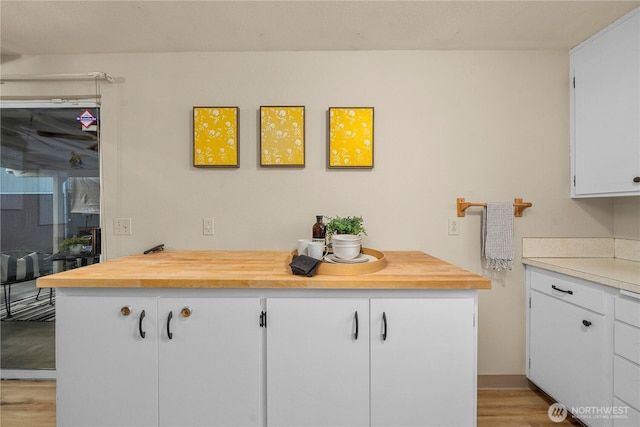 7052 S I St, Tacoma, WA 98408 - kitchen with wood counters, light wood-type flooring, and white cabinets
