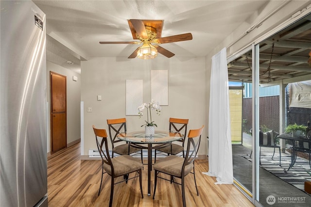 7052 S I St, Tacoma, WA 98408 - dining room with light wood-style floors, a ceiling fan, baseboards, and a baseboard radiator