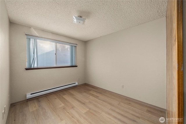 7052 S I St, Tacoma, WA 98408 - spare room featuring baseboard heating, light wood-type flooring, and a textured ceiling