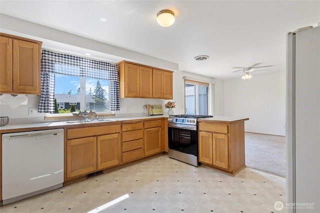 1274 Admirals Dr, Coupeville, WA 98239 - kitchen with stainless steel range with gas stovetop, dishwasher, a sink, freestanding refrigerator, and a peninsula