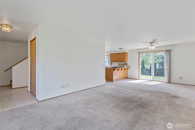 1274 Admirals Dr, Coupeville, WA 98239 - unfurnished living room featuring a ceiling fan, light colored carpet, and stairs